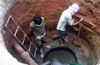 Work inside manhole while sewage uninterrupted in city